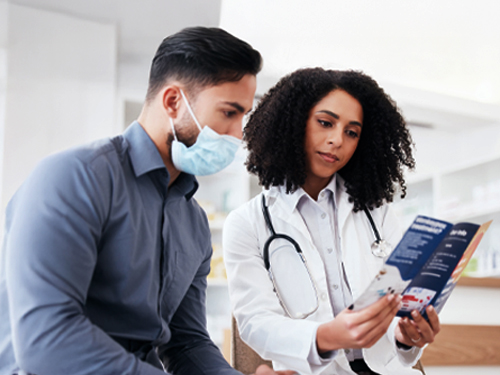 A doctor and a patient looking at a brochure together